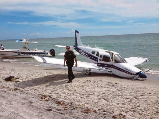 Sarasota County Sheriff's Office shows emergency personnel at the scene of a small plane crash in Caspersen Beach in Venice, Fla. Authorities say a father was killed and his daughter seriously injured while walking on the sand when a small plane crash landed along Florida's Gulf Coast near Venice Beach.AP Photo