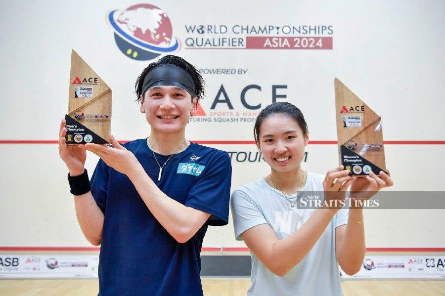 Chan Yi Wen (right) who won the women's category along with a player from Japan, Ryunosuke Tsukue who won the men's category, holding the trophy after the final match of the 2024 World Champion Qualification Squash Championship in Kuala Lumpur. - NSTP/AIZUDDIN SAAD