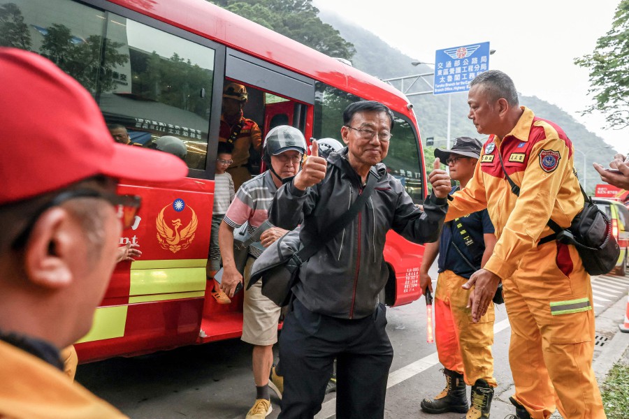 A man gestures as he gets out of a van at a temporary rescue command post after being rescued from the Taroko National Park in Hualien on April 5, 2024 following the April 3 earthquake. Ten people were killed and nearly 1,100 injured in the April 3 magnitude-7.4 quake, but strict building regulations and widespread public disaster awareness appear to have staved off a major catastrophe on the island. AFP PIC