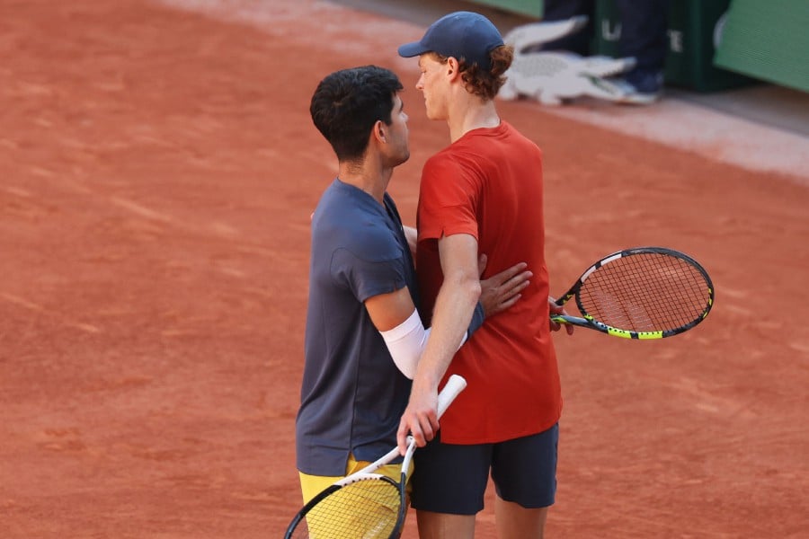 Spain's Carlos Alcaraz (L) speaks with Italy's Jannik Sinner after winning at the end of their men's singles semi final match on Court Philippe-Chatrier on day thirteen of the French Open tennis tournament at the Roland Garros Complex in Paris on June 7, 2024. AFP PIC