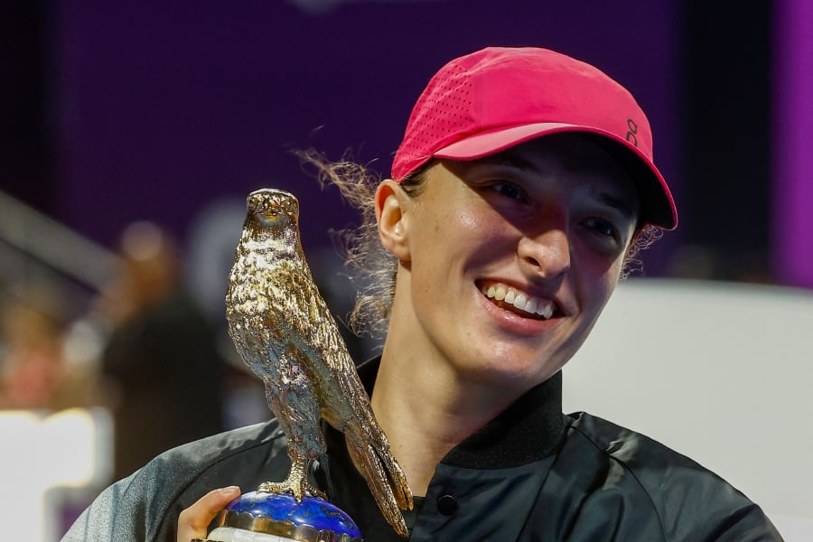 Iga Swiatek of Poland lifts the trophy after winning against Elena Rybakina of Kazakhstan in the final of the Qatar Open in Doha on February 17, 2024. AFP