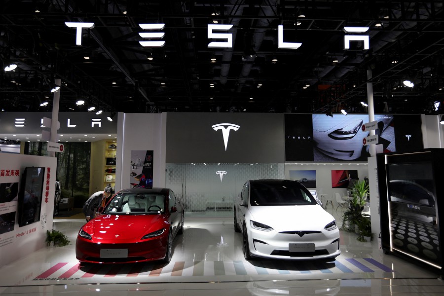 A staff member looks at Tesla's new Model 3 sedan displayed next to Model X SUV at the China International Fair for Trade in Services (CIFTIS) in Beijing, China September 2, 2023. -REUTERS PIC