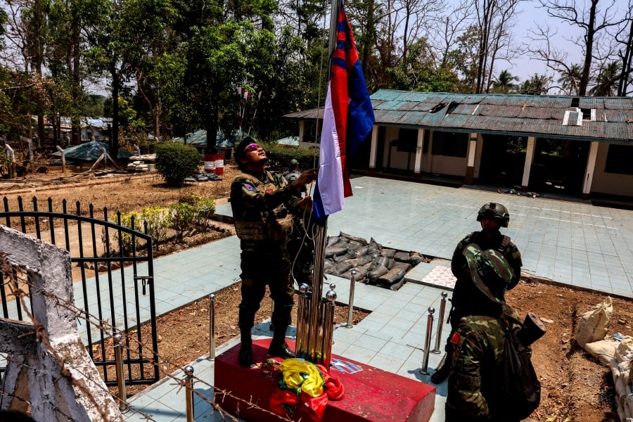 (FILE PHOTO) LT Saw Kaw, a soldier of the Karen National Liberation Army (KNLA) in charge of the Cobra column, raises Karen's national flag after burning Myanmar's national flag at a Myanmar military base at Thingyan Nyi Naung village on the outskirts of Myawaddy, the Thailand-Myanmar border town. (REUTERS/Athit Perawongmetha/File Photo)