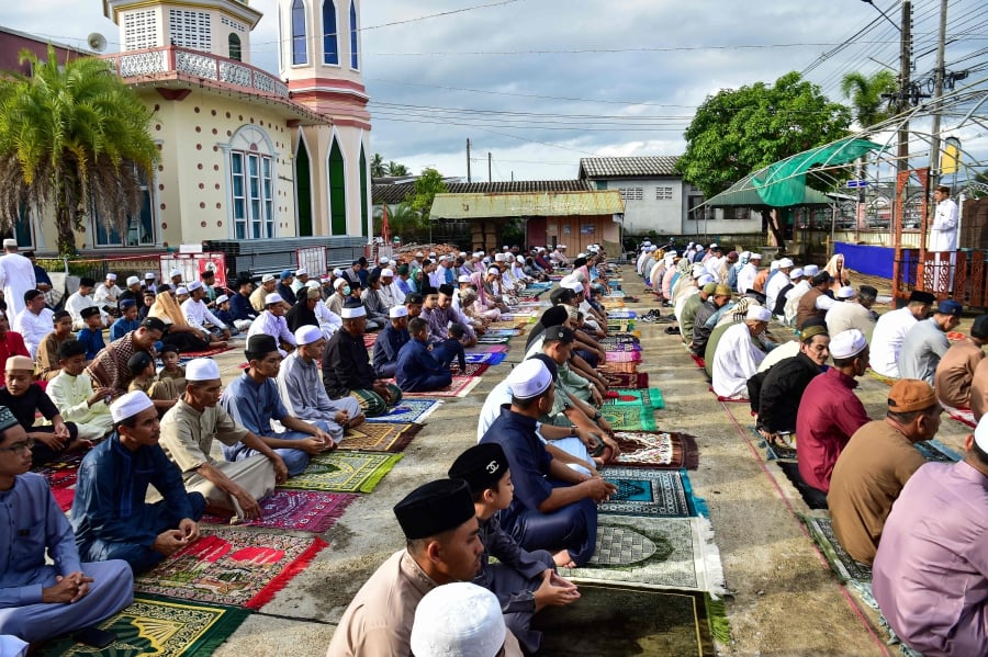 Thai Muslims offer prayers at the start of the Aidilfitri festival, which marks the end of their holy fasting month of Ramadan, in the southern Thai province of Narathiwat. (Photo by Madaree TOHLALA / AFP)