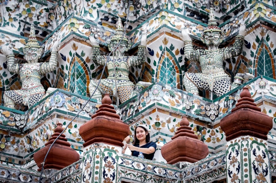 A tourist visits Wat Arun, the Temple of Dawn, in Bangkok, Thailand, 04 May 2022. Thailand has lifted arrival restrictions for fully vaccinated travelers arriving by air. (EPA/DIEGO AZUBEL)
