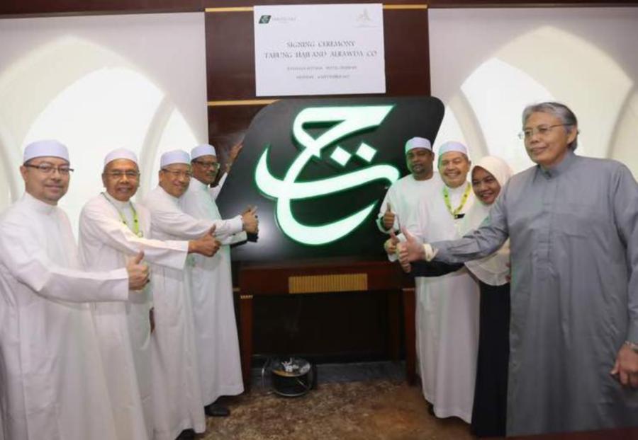 TH chairman Datuk Seri Abdul Azeez Abdul Rahim (4th right) said the prominent placement of the logo would enable easy identification of the buildings by pilgrims staying there. Pic by NSTP/ courtesy of Tabung Haji 
