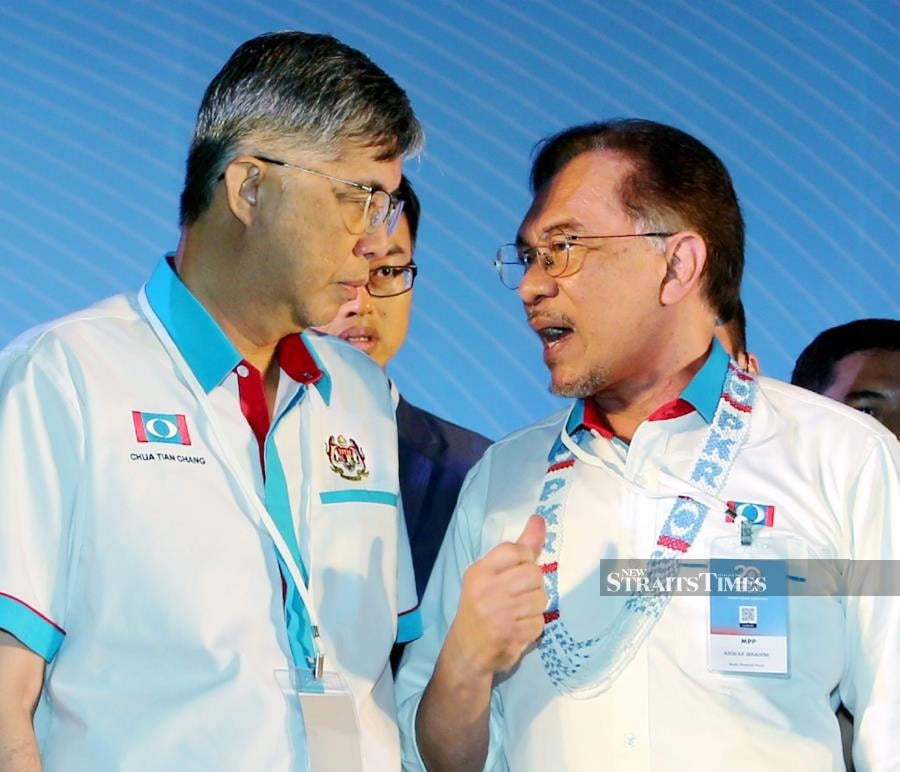 PKR president Datuk Seri Anwar Ibrahim (right) talking to vice-president Tian Chua at the party’s national congress in Melaka yesterday. PIC BY RASUL AZLI SAMAD 