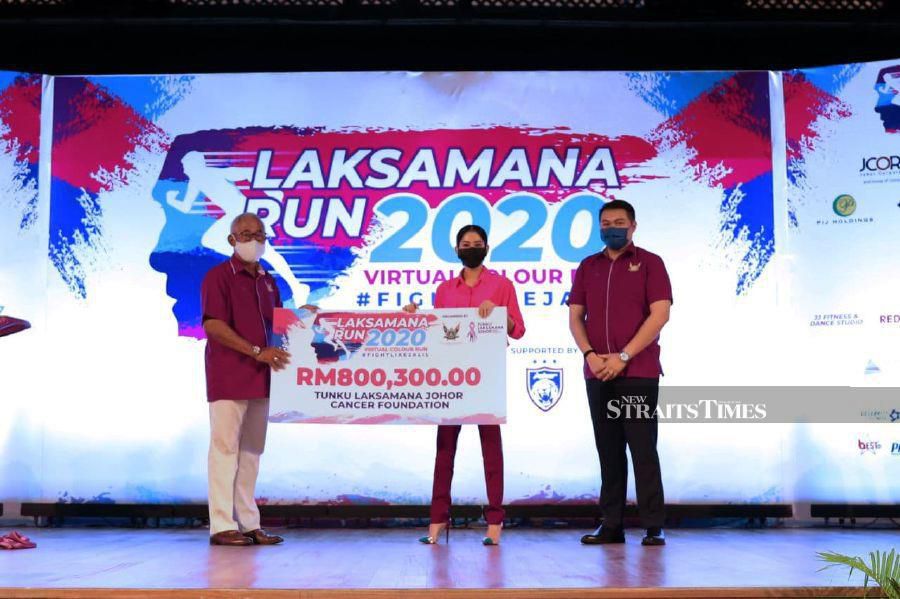 Tunku Tun Aminah (centre) receiving the cheque for the funds received during the event.- Photo courtesy of TLJCF.