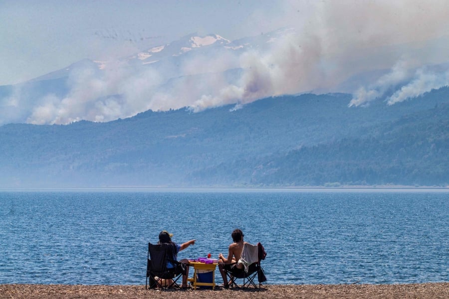 Tourists looking at smoke billowing from a forest fire at Los Alerces National Park in Chubut province, Argentina. (Photo by MARTIN LEVICOY / TELAM / AFP) 