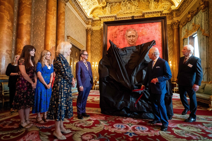 Britain's Queen Camilla (fourth from left) watches as Britain's King Charles III (second from right) unveils an official portrait of himself, by artist artist Jonathan Yeo (fifth from left), depicting the King wearing the uniform of the Welsh Guards, of which he was made Regimental Colonel in 1975, in the Blue Drawing Room at Buckingham Palace in London. (Photo by Aaron Chown / POOL / AFP) 