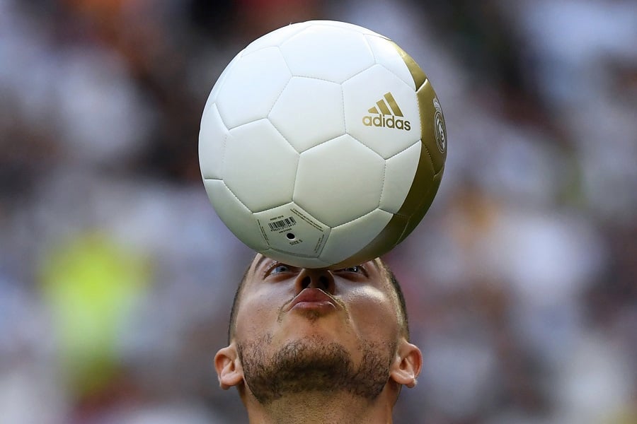 Belgian footballer Eden Hazard plays with a ball during his official presentation as new player of the Real Madrid CF at the Santiago Bernabeu stadium in Madrid. -- Image by AFP