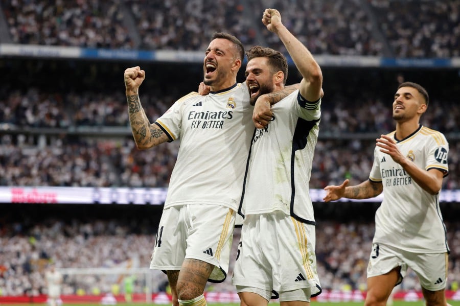 Real Madrid's Spanish forward #14 Joselu (L) celebrates scoring his team's third goal, with Real Madrid's Spanish defender #06 Nacho Fernandez, during the Spanish league football match between Real Madrid CF and Cadiz CF at the Santiago Bernabeu stadium in Madrid on May 4, 2024. AFP PIC
