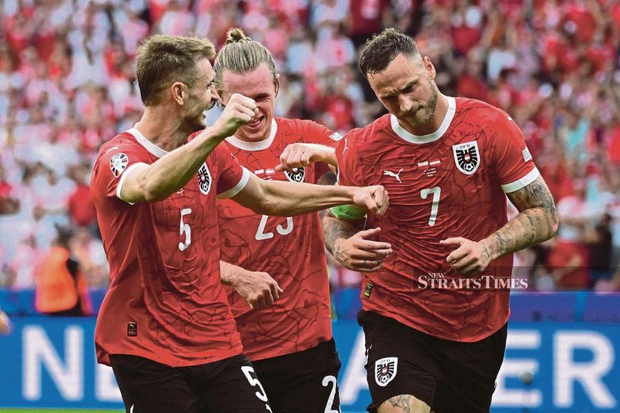 Austria players celebrate a goal against Poland during Friday’s Euro 2024 Group D match in Berlin. AFP PIC 