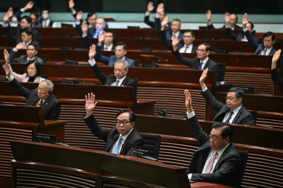 Lawmakers vote for Article 23 in the chamber of the Legislative Council after the conclusion of the readings of the Article 23 National Security Law, in Hong Kong. (Photo by Peter PARKS / AFP)