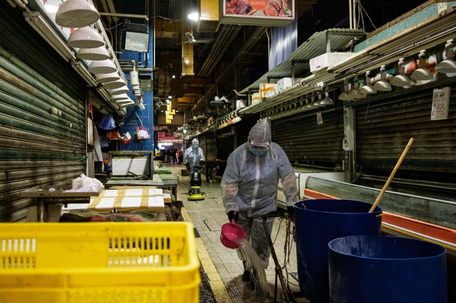 Food and Environmental Hygiene Department (FEHD) contractors take part in a cleaning and disinfection of Pei Ho Street Market in the Sham Shui Po district of Hong Kong as the city experiences another spike in COVID-19 coronavirus cases. -AFP pic