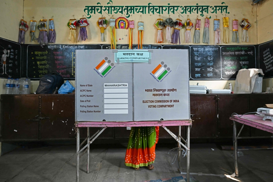 A voter casts her ballot at a polling station during the fourth phase of voting in India�s general election, in Karjat of Maharashtra state. (Photo by Indranil Mukherjee / AFP)