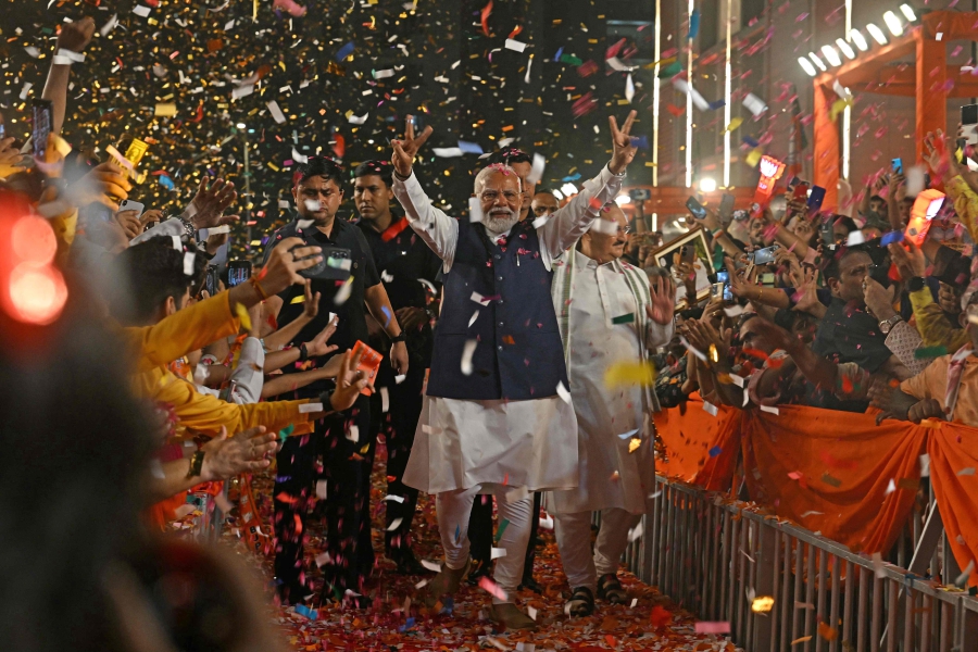 India’s Prime Minister Narendra Modi (centre) flashes victory sign as he arrives at the Bharatiya Janata Party (BJP) headquarters to celebrate the party’s win in country's general election, in New Delhi. (Photo by Arun SANKAR / AFP)
