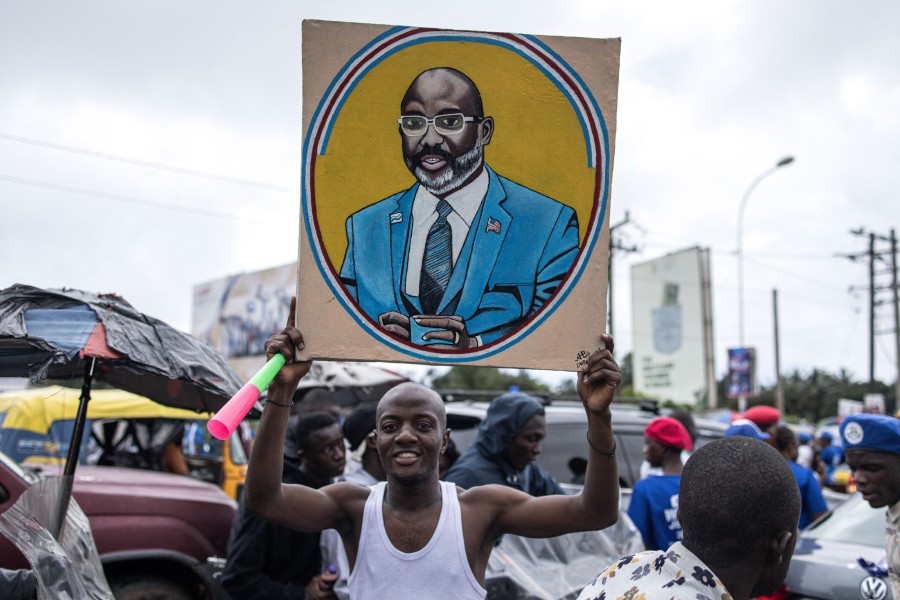 A supporter holds up a painting of Liberian President George Weah ahead of a final campaign rally in Monrovia, on October 8, 2023. AFP PIC