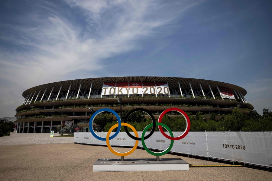 This picture shows the Olympic rings and Olympic Stadium in Tokyo on July 20, 2021, ahead of the Tokyo 2020 Olympic Games. (Photo by Behrouz MEHRI / AFP)