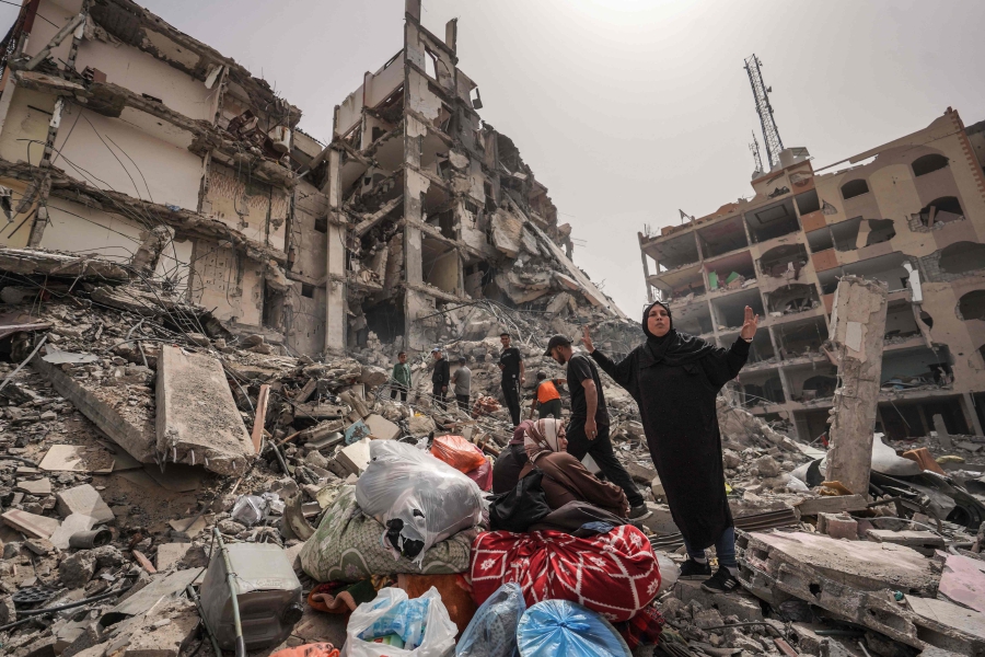 Palestinians inspect the damage to a building in the city of Nuseirat in the central Gaza Strip, amid ongoing battles between Israel and the fighter Hamas group. (Photo by AFP)