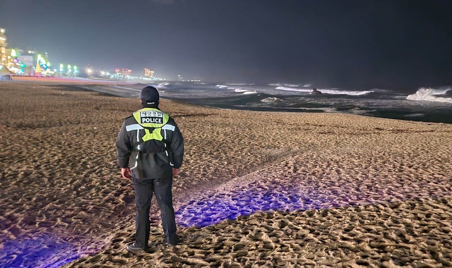 A South Korean Coast Guard member patrols a beach in Gangneung on January 1, 2024, as South Korea issued tsunami advisory after a major earthquake in Japan. A succession of 21 earthquakes registering 4.0 magnitude or stronger struck central Japan in just over 90 minutes on January 1, the Japan Meteorological Agency said. - AFP pic