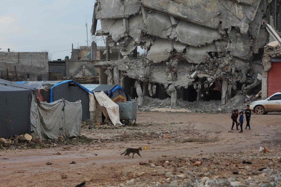  Children walk past a destroyed building next to tents set up at a camp for quake-displaced Syrians in Jindayris town in the northwest of Aleppo province, one year after a massive earthquake hit the border area in northern Syria and Turkey. On February 6, 2023, a devastating quake ravaged Turkey and Syria, killing more than 1,400 people in government-controlled areas of Syria, while more than 4,500 died and tens of thousands were injured in areas held by opposition factions in the country's northwest according to Damascus. Jindayris, in Aleppo province near the border with Turkey, was one of the areas worst-hit. - AFP pic
