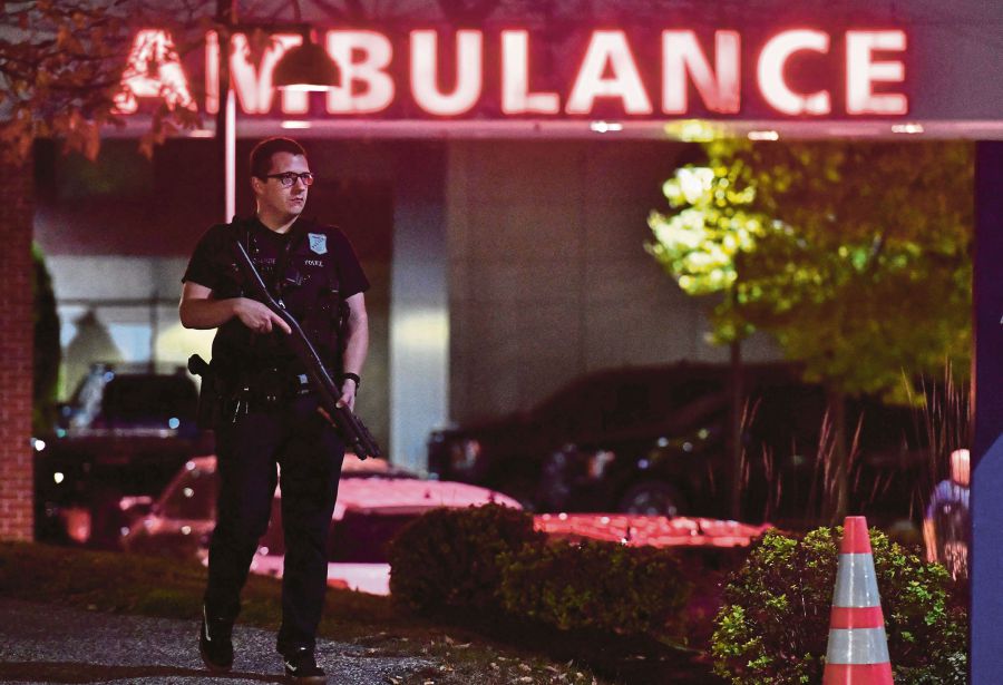 An armed police officer guards the ambulance entrance to the Central Maine Medical Center in Lewiston, Maine early on October 26, 2023. - AFP Pic