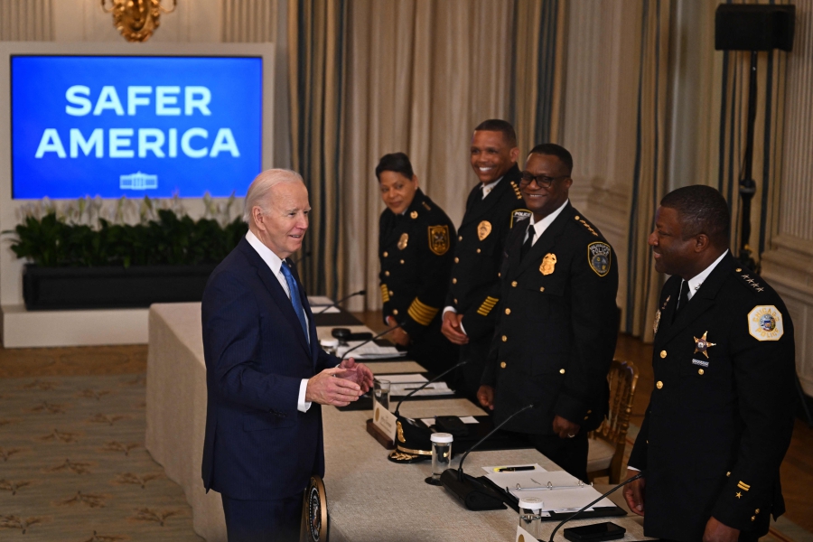 US President Joe Biden greets police officers as he arrives to speak about his administration's efforts to fight crime and make our communities safer, in the State Dining Room of the White House in Washington, DC. (Photo by Jim WATSON / AFP)