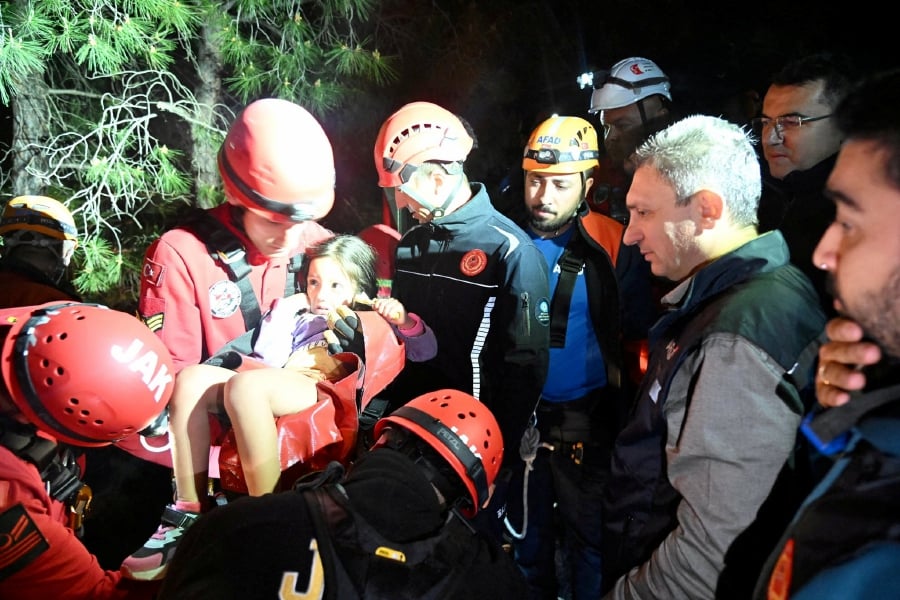 A girl is carried by a member of Gendarmerie Search and Rescue (JAK) team during a rescue operation after a cable car cabin collided with a broken pole, in Antalya, Turkey, April 12, 2024. Antalya Governorship/Handout via REUTERS
