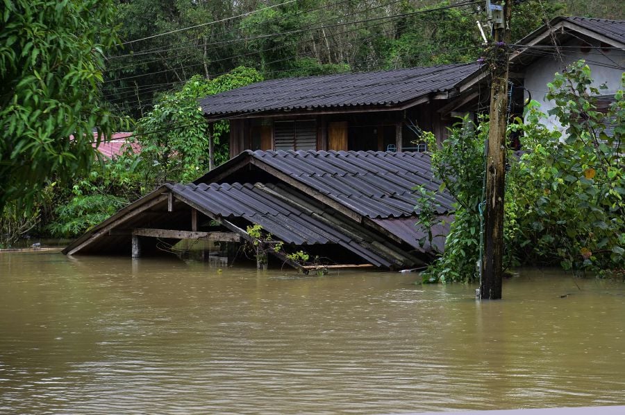 A house is seen submerged in floodwaters following heavy rain in Thailand's southern province of Narathiwat. At least six people died and nearly 70,000 households have been affected following floods in five provinces in southern Thailand. - AFP pic