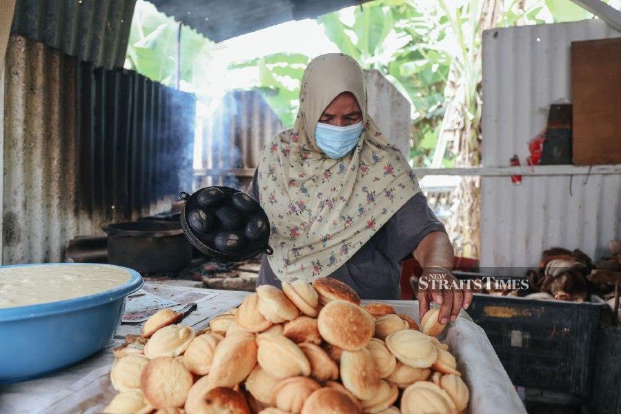 A local entrepreneur making Kuih Bahulu using a traditional baking methods. - NSTP/ FAUSTINA HII 