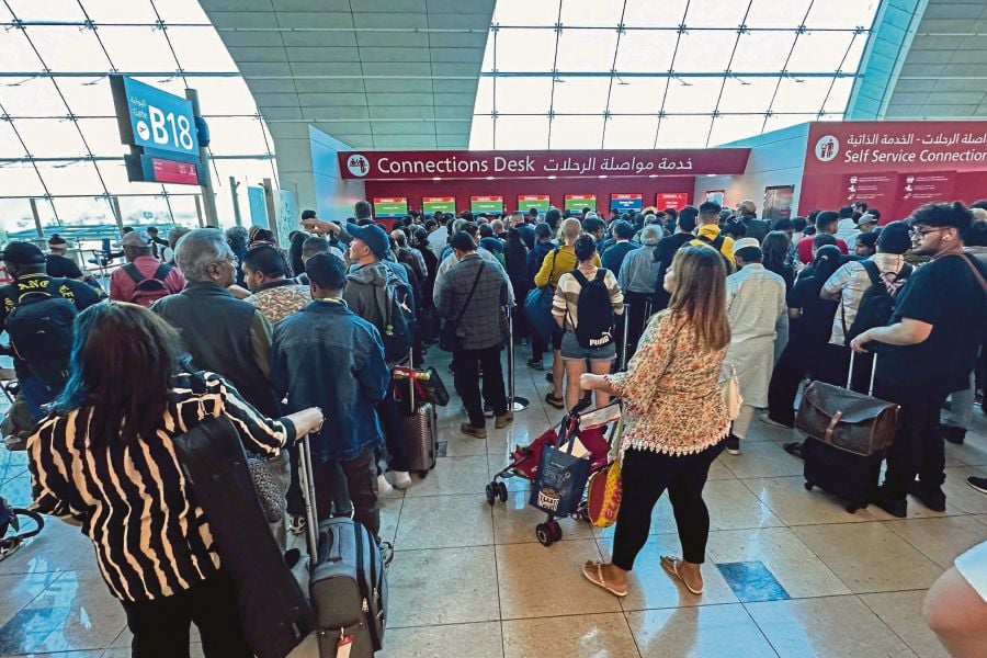 Passengers queue at a flight connection desk at the Dubai International Airport in Dubai. (Photo by AFP)
