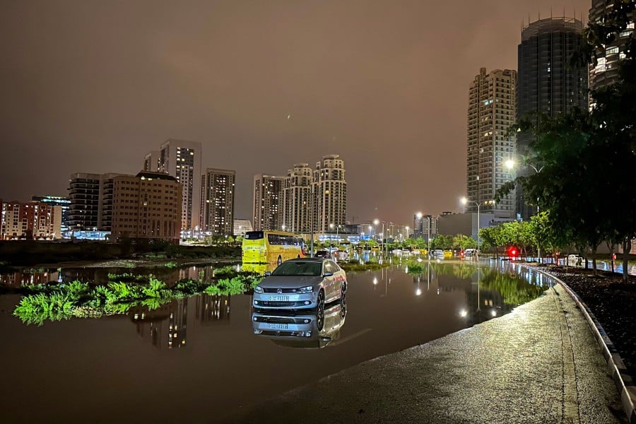 A car is left on a flooded street following heavy rains in Dubai early on April 17, 2024. AFP PIC