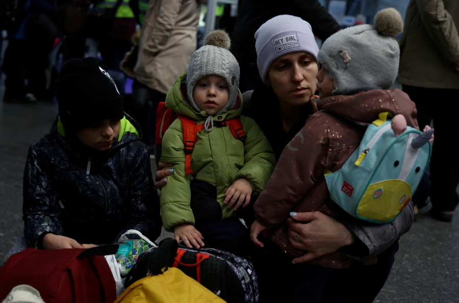 A mother waits with her children at the main hall of the Central train station, following the Russian invasion of Ukraine, in Warsaw, Poland March 9, 2022. (Photo by REUTERS/Kacper Pempel)