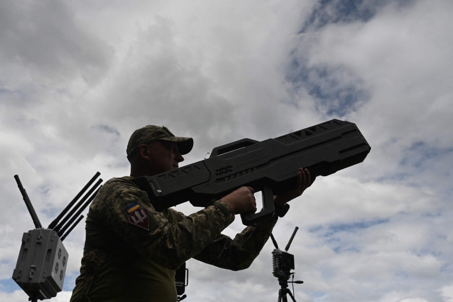 A Ukrainian serviceman tests an anti-drone gun during a presentation of radio-electronic warfare (WB) and radio-electronic intelligence (PER) systems of the Ukrainian company Kvertus in Lviv region on May 28, 2024, amid the Russian invasion of Ukraine. AFP