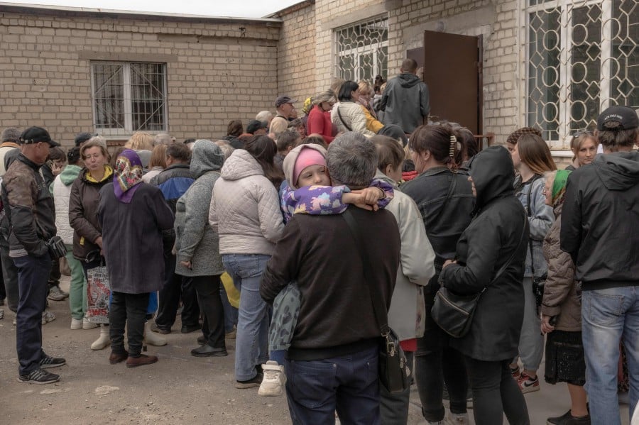 People who have fled from different areas of the Kharkiv region wait in a queue to be registered at an evacuation point in Kharkiv, today (May 14), amid the Russian invasion of Ukraine. Also in Kharkiv, hundreds of children began lessons this week in Ukraine’s first purpose-built bunker school, 6m below the ground to protect them from Russian drone and missile attacks. — AFP