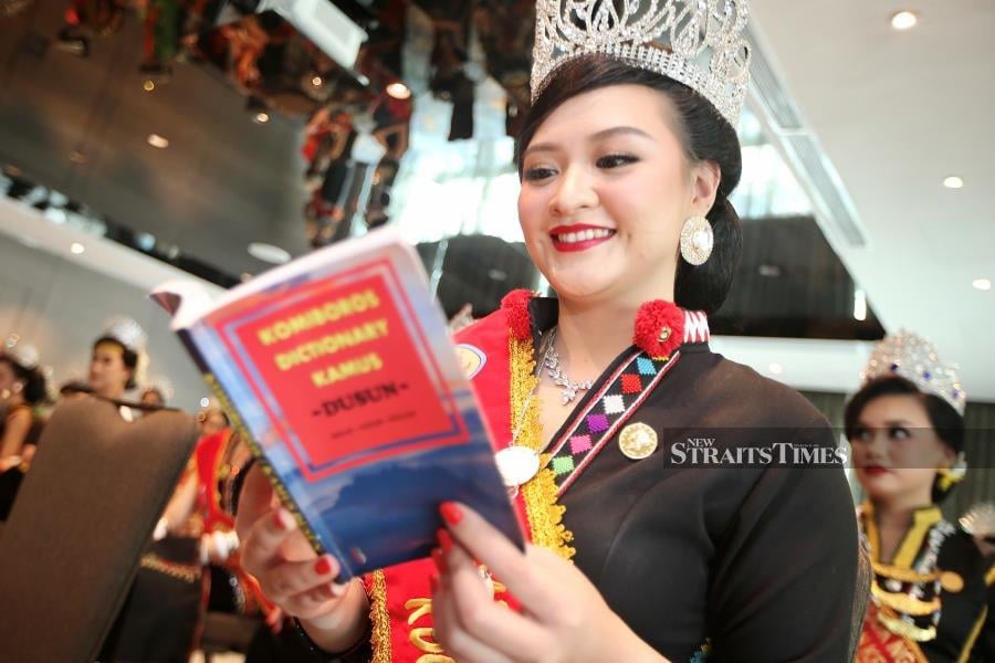 Romandawi Gapari, seen here with her trusty Dusun dictionary, is one of 51 contestants vying for this year’s national Unduk Ngadau title. NSTP/ Mohd Adam Arinin
