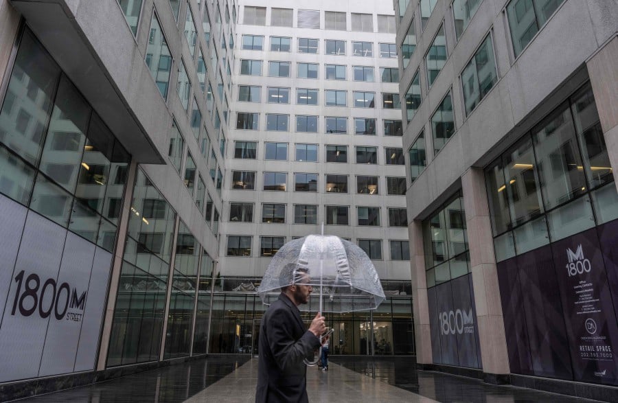 A man walks past a building with office space for rent in Washington, DC, on March 6, 2024. The popularity of remote work in the US has emptied office buildings, a cause for worry as their value falls and owners risk losses on property loans, in turn weighing on smaller banks. "There are some institutions that will face stresses from commercial real estate," said US Treasury Secretary Janet Yellen in March 2024. But she said during a congressional hearing that overall, the country's banking system remained "well-capitalized." (Photo by ANDREW CABALLERO-REYNOLDS / AFP)