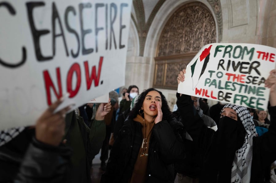 Pro-Palestine demonstrators rally in the lobby of City Hall while the City Council debates a symbolic resolution calling for a cease-fire in the war between Israel and Hamas in Chicago, Illinois. (Photo by SCOTT OLSON / GETTY IMAGES NORTH AMERICA / Getty Images via AFP)