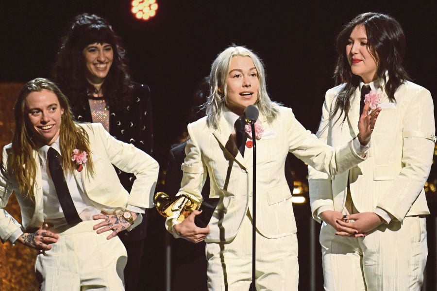 Julien Baker, Phoebe Bridgers and Lucy Dacus of US indie group boygenius accept the award for Best Alternative Music Album for "The Record" on stage during the 66th Annual Grammy Awards pre-telecast show at the Crypto.com Arena in Los Angeles. (Photo by VALERIE MACON / AFP)