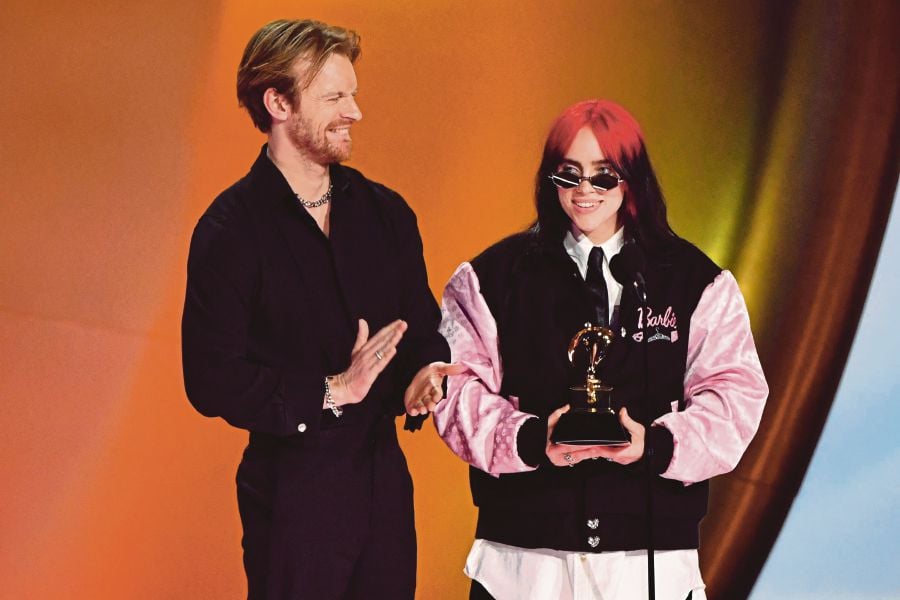 US singer-songwriter Billie Eilish (right) and US singer-songwriter Finneas O'Connell accept the Song Of The Year award for "What Was I Made For?" on stage during the 66th Annual Grammy Awards at the Crypto.com Arena in Los Angeles. (Photo by Valerie Macon / AFP)