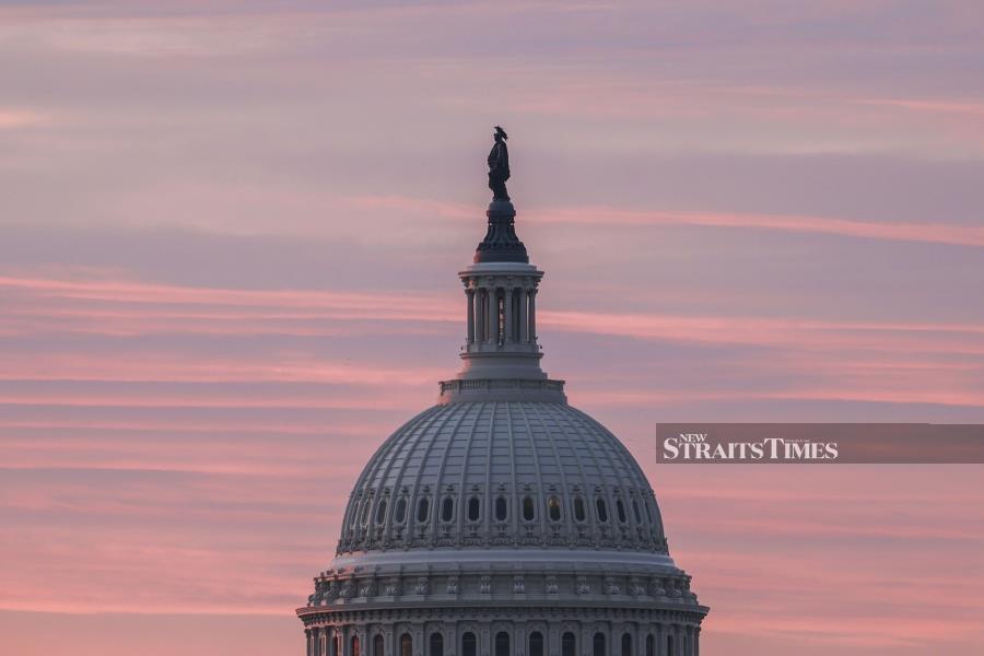 The sun rises over the US Capitol on Dec 28, 2020 in Washington, DC. The US has seen a troubling surge in coronavirus cases in recent months. As of Monday evening, the country had recorded 19,526,228 cases with 337,918 deaths, both by far the worst tolls in the world (Photo by Tasos Katopodis/Getty Images/AFP) TASOS KATOPODIS