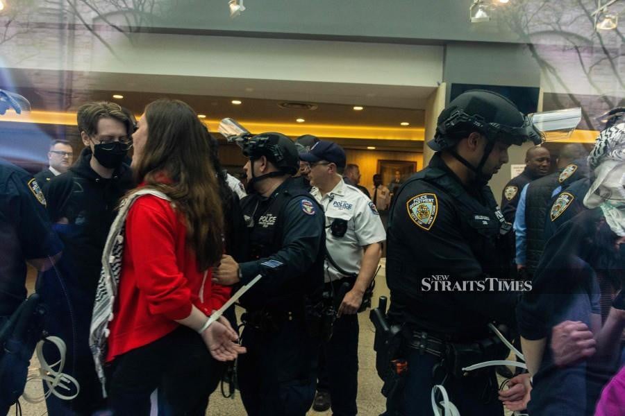 Police arrest pro-Palestinian protesters occupying a building where they had established an encampment at Fordham University Lincoln Center campus on May 01, 2024 in New York City. The occupation of the building comes a day after police raided both Columbia University and City College, arresting dozens and closing down encampments there. -AFP/ALEX KENT