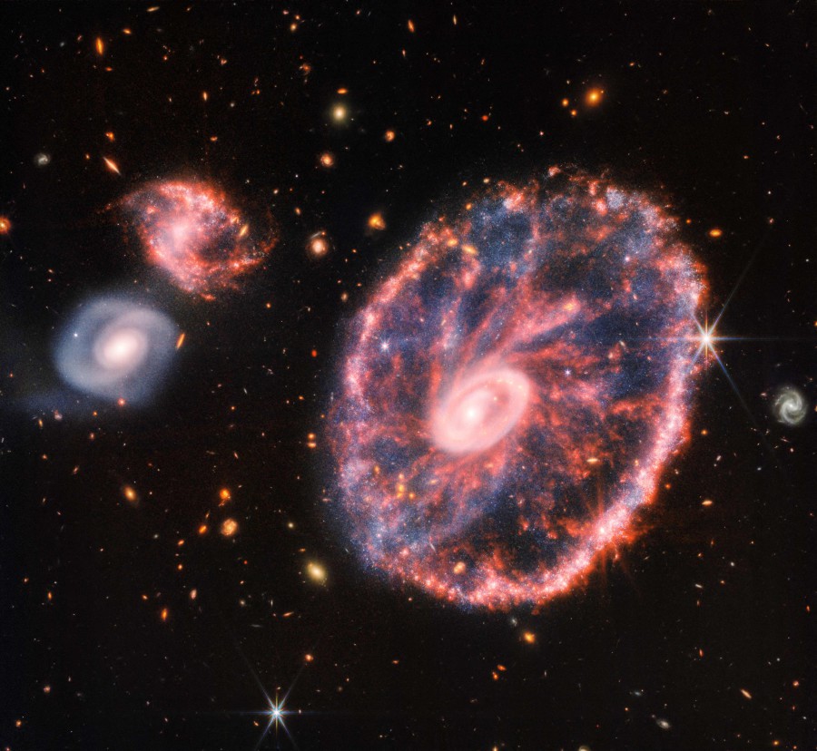 This composite image from Webb’s Near-Infrared Camera (NIRCam) and Mid-Infrared Instrument (MIRI) released by NASA on August 2, 2022, shows the Cartwheel and its companion galaxies, revealing details that are difficult to see in the individual images alone. - This galaxy formed as the result of a high-speed collision that occurred about 400 million years ago. The Cartwheel is composed of two rings, a bright inner ring and a colorful outer ring. Both rings expand outward from the center of the collision like shockwaves. This snapshot provides perspective on what happened to the galaxy in the past and what it will do in the future. (Photo by Space Telescope Science Institut / NASA / AFP)