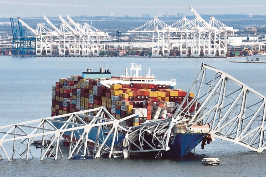 The Francis Scott Key Bridge sits on top of a container ship after the bridge collapsed, Baltimore, Maryland. (Photo by Jim WATSON / AFP)