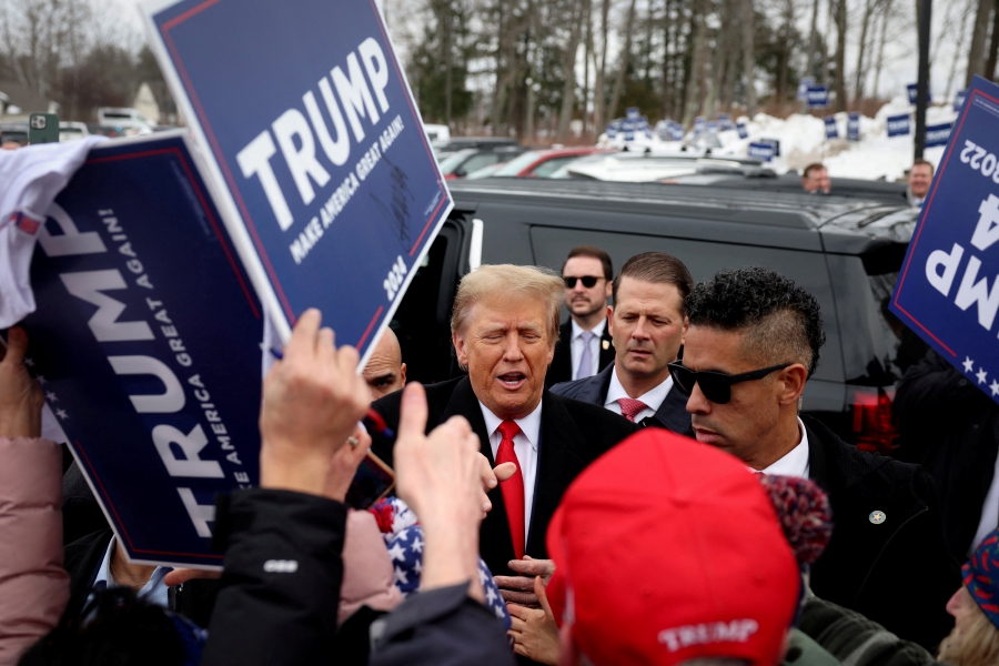 Former U.S. President and Republican presidential candidate Donald Trump greets supporters as makes a visit to a polling station on election day in the New Hampshire presidential primary in Londonderry, New Hampshire. (REUTERS/Mike Segar)