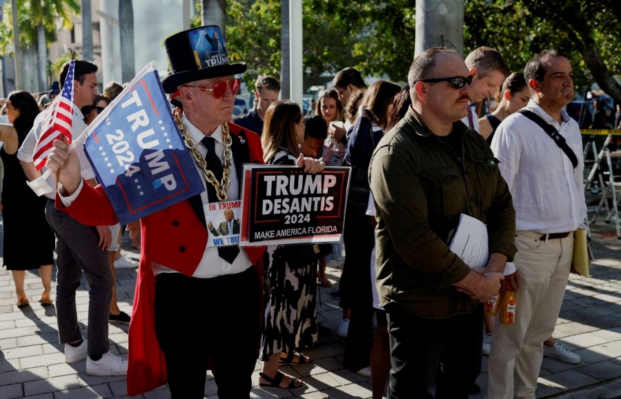 A supporter of former U.S. President Donald Trump and other people stand outside The Wilkie D. Ferguson Jr. United States Courthouse, on the morning former U.S. President Trump is to appear there on classified document charges, in Miami, Florida, U.S. (REUTERS/Marco Bello REFILE)