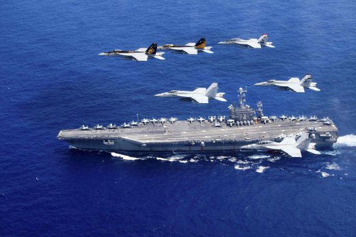 A combined formation of aircraft from Carrier Air Wing (CVW) 5 and Carrier Air Wing (CVW) 9 pass in formation above the Nimitz-class aircraft carrier USS John C. Stennis (CVN 74) in the Philippine Sea on June 18, 2016. Two US aircraft carriers have started exercises in the Philippine Sea, defence officials said Sunday, as Washington’s close ally Manila faces growing pressure from Beijing in the South China Sea. Photo courtesy Steve Smith/U.S. Navy