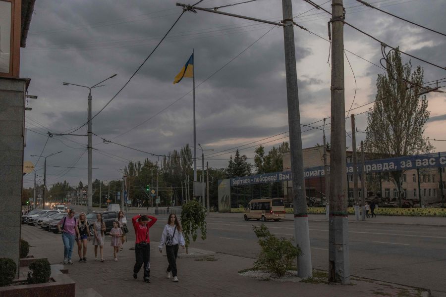 Pedestrians walk past a Ukrainian flag in Kryvyi Rih, southern Ukraine, amid the Russian invasion of Ukraine. - AFP pic