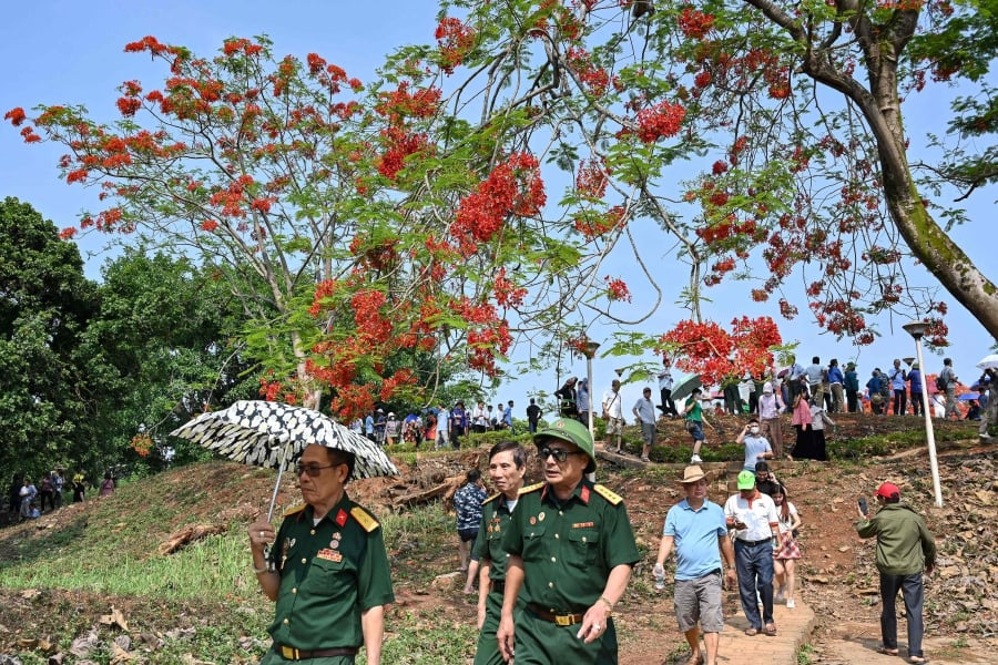 Vietnamese veterans walk down A1 hill historical battle site in Dien Bien Phu city. (Photo by Nhac NGUYEN / AFP)